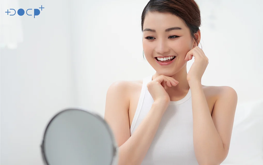 Woman Smiling Looking At Her Face Though The Mirror